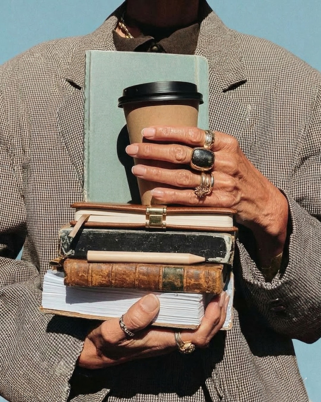 Un docente con una pila di libri e un caffè