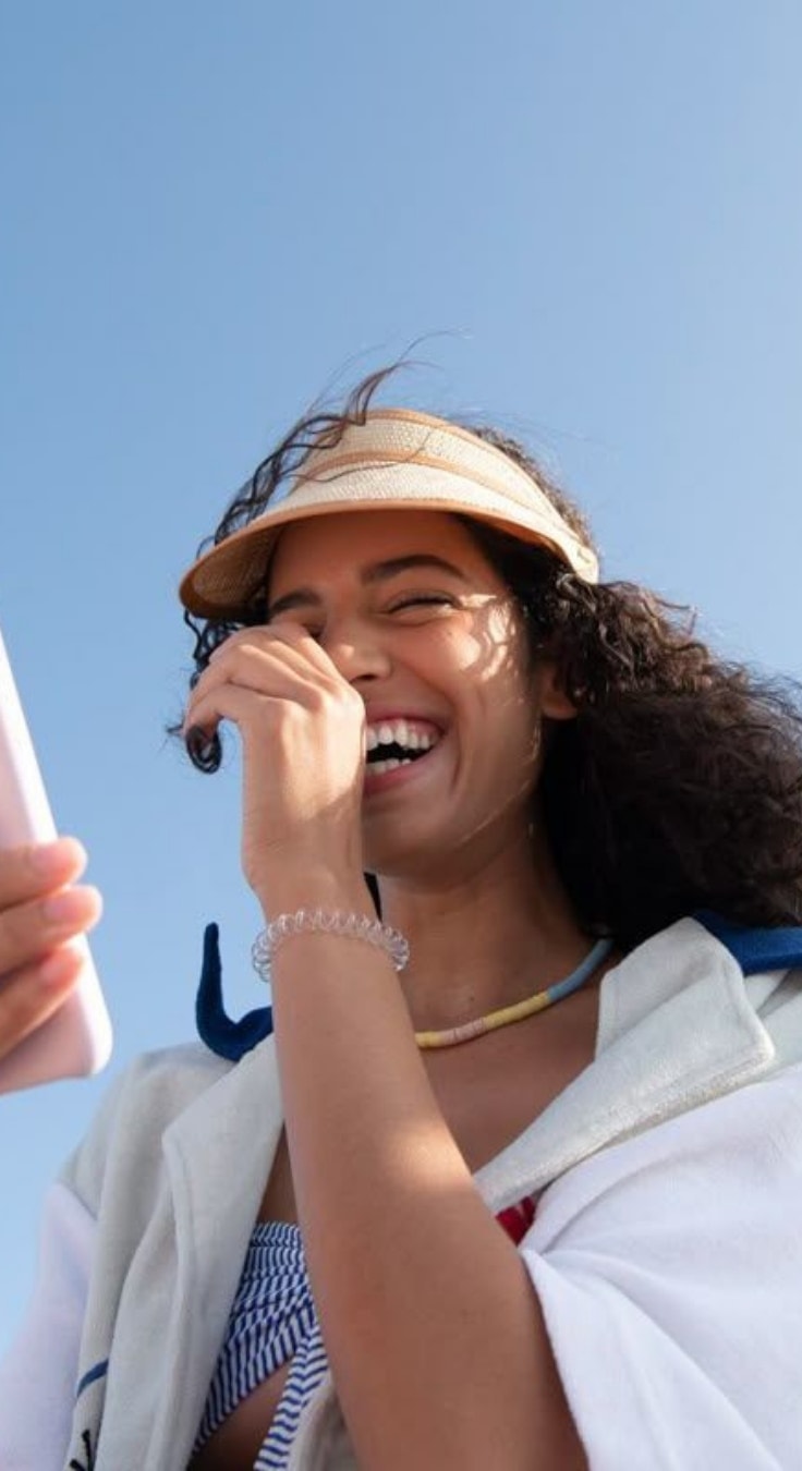 Una studentessa ride guardando il telefono